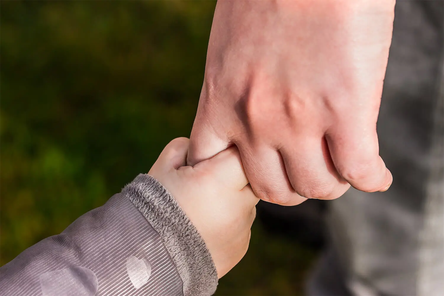 Un padre prende per mano il figlio.