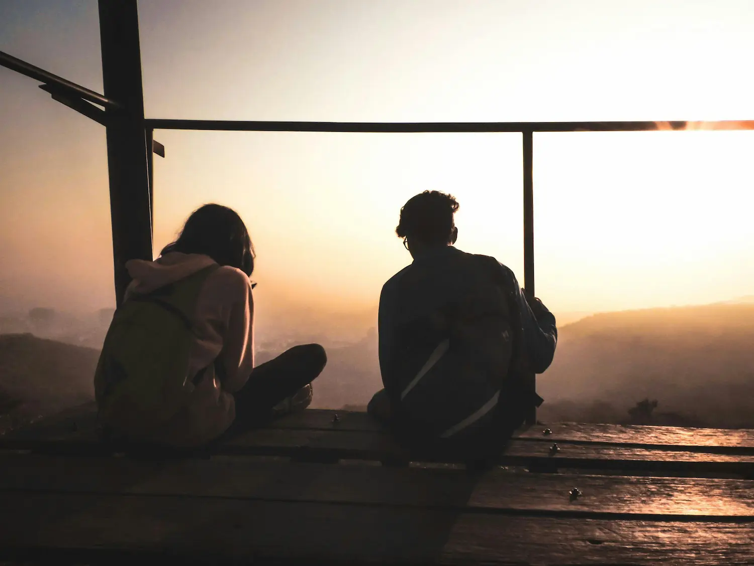 Due ragazzi che parlano di fronte ad un tramonto.